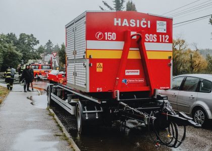 Fire department emergency vehicle stationed outdoors in rainy weather.